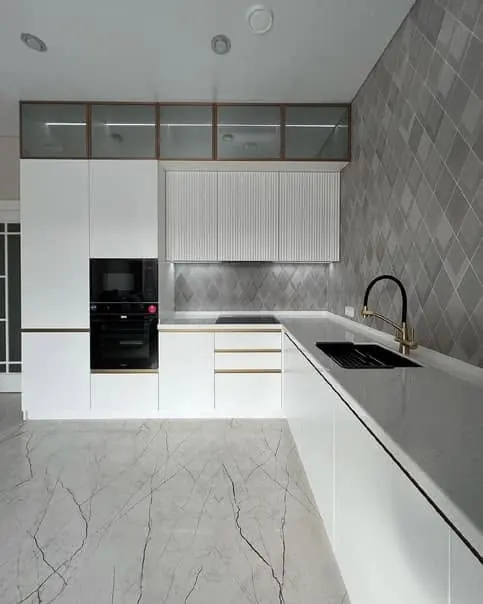 Cucina bianca ad angolo con ante cannettate e pensili in vetro