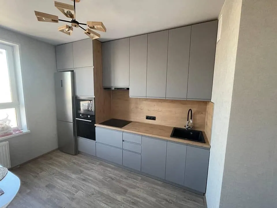 Cucina lineare grigia con top effetto legno e lavello nero