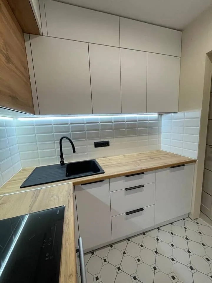 Cucina bianca con top in legno e luci LED sotto i pensili